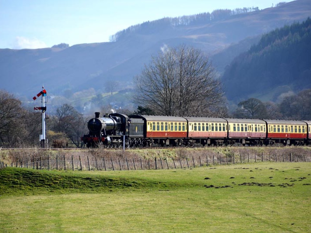 a train traveling down train tracks near a mountain