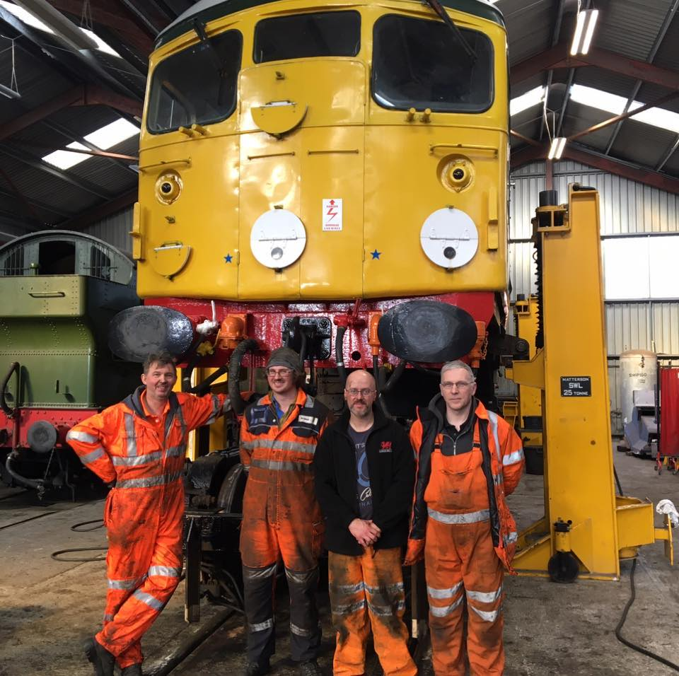 a group of people standing next to a train